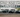 A lineup of budget drift cars like the 350Z, E36, and IS300 sliding at a drift event