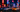 Iconic Tokoyo Drift cars lined up with vibrant city lights in the background.