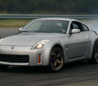Nissan 350Z with upgraded SLR angle kit mid-drift showing extreme steering angle on a track
