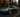 Slammed Nissan 350Z with a wide body kit and huge rear wing rolling through a New York City street at dusk, captured mid corner with motion blur.