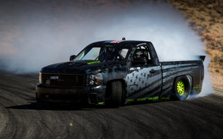 Pickup truck mid-drift with high steering angle and modified front suspension setup