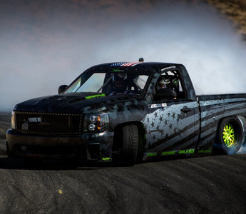 Pickup truck mid-drift with high steering angle and modified front suspension setup