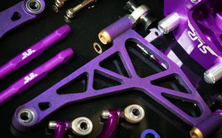 SLR 350Z angle kit components laid out on a shop bench with control arms, knuckles, and tie rods visible