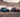 BMW E36 and BMW E46 drift cars with full racing livery sliding in tandem through the Oman desert, throwing tire smoke during a high speed drift run, wide 16:9 motorsport action scene