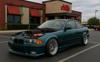 A slammed BMW E36 with NASCAR V8 engine exposed, parked in a Chili’s restaurant parking lot.