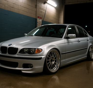 Lowered BMW E46 on coilovers at a night car wash, featuring aggressive stance, deep wheels, and performance suspension setup.
