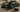A high-resolution photo of a lowered sports car positioned on low-profile split-style car ramps inside a garage, with an oil drain pan and tools placed nearby — ideal setup for a clean DIY oil change.
