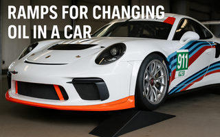 A Porsche 911 race car on SLR ramps for changing oil