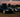 BMW E46 and C5 Corvette lined up in the paddock, tires mounted, ready for drifting under trackside lights