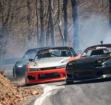 Three drift cars on a mountain pass drifting with different styles and techniques