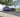 Drift car mid-slide with front wheels countersteered and smoke pouring off rear tires at full opposite lock