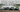 A lineup of budget drift cars like the 350Z, E36, and IS300 sliding at a drift event
