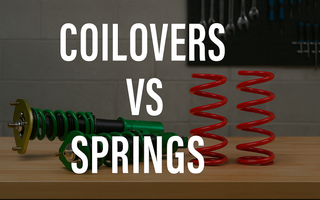 Comparison of coilovers and lowering springs side by side on a garage workbench