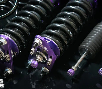 A set of coilovers on the table next to a set of springs