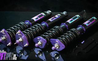 Coilover suspension installed on modified car showing spring and damper as one adjustable unit.