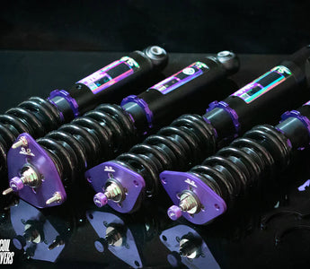 Coilover suspension installed on modified car showing spring and damper as one adjustable unit.