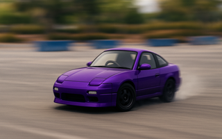 Chibi-style DriftKart D1 mid-slide in a parking lot, sized for adult rider with helmet and racing posture
