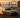 A drift car sliding sideways on a mountain road with tire smoke, showing oversteer control and driver precision