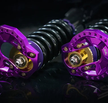 Close-up of purple SLR E30 camber plates mounted to a strut assembly
