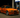 Orange widebody BMW E36 M3 slammed at a gas station pump at night with the front wheels turned, showcasing aggressive stance, drift fitment, and performance styling with E36 angle kit.