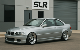 Slammed silver BMW E46 coupe parked in front of an office building.