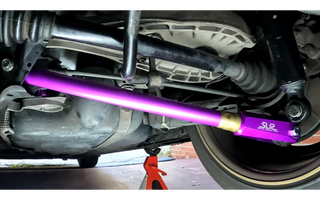purple anodized E46 rear control arms close-up installed on car