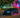 Slammed BMW E46 with a wide body kit and huge rear wing rolling through a Miami Beach street, captured mid corner with palm trees and neon lighting in the background.