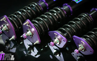 Close up shot of GR86 coilovers sitting on a dark table