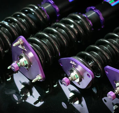 Close up shot of GR86 coilovers sitting on a dark table