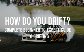 A drift car mid-slide with smoke, countersteer, and crowd in background at a drift track