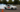 Rear-wheel-drive car initiating a controlled drift around a cone during a drift clinic