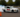 Rear-wheel-drive car initiating a controlled drift around a cone during a drift clinic