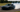 Car mid-drift on a closed track, tires smoking, showing perfect countersteer control