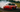 A red 240sx doing a 360 drift on track with smoke coming out of back tires