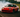 A red 240sx doing a 360 drift on track with smoke coming out of back tires