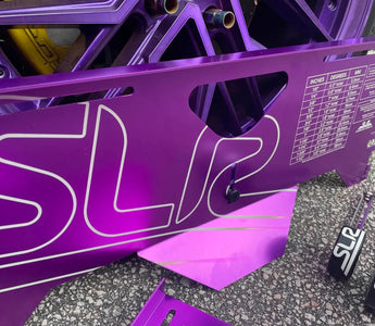 A set of SLR toe plates and tape measures on the ground next to a car getting aligned