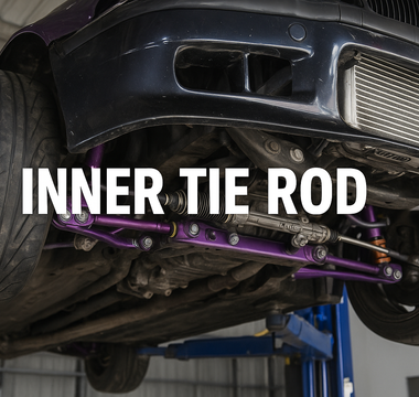 A BMW E36 up on a lift showing the underside of the car with tie rods and control arms