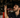 A mechanic looking at a inner tire rod on a car which is on a lift