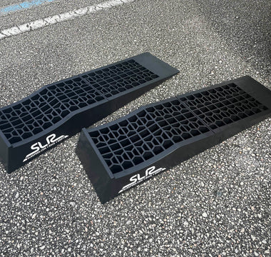 Low profile auto ramps on driveway next to race car
