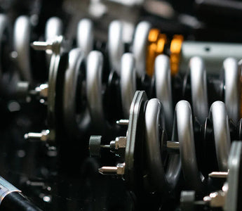 Close up photo of S-Class coilover conversion springs and sway bar laying on a table
