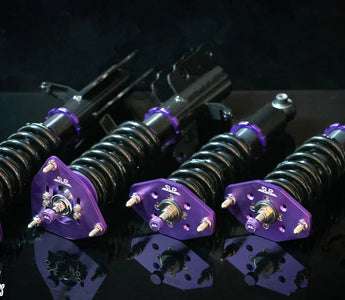 sn95 coilovers laid out on a black table