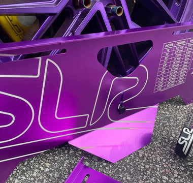 Adjusting wheel alignment using toe plates on a performance drift car, showing detailed alignment process with measurement tape and precision setup.
