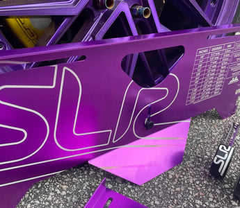 Set of adjustable toe plates positioned under wheels of a lowered car in a garage