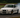 BMW E36 drift car on track with visible angle kit, coilovers, and steering mods